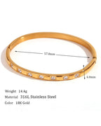 Gold bracelet with measurements and material details on a white background
