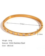 Gold bracelet with measurements and material details on a white background