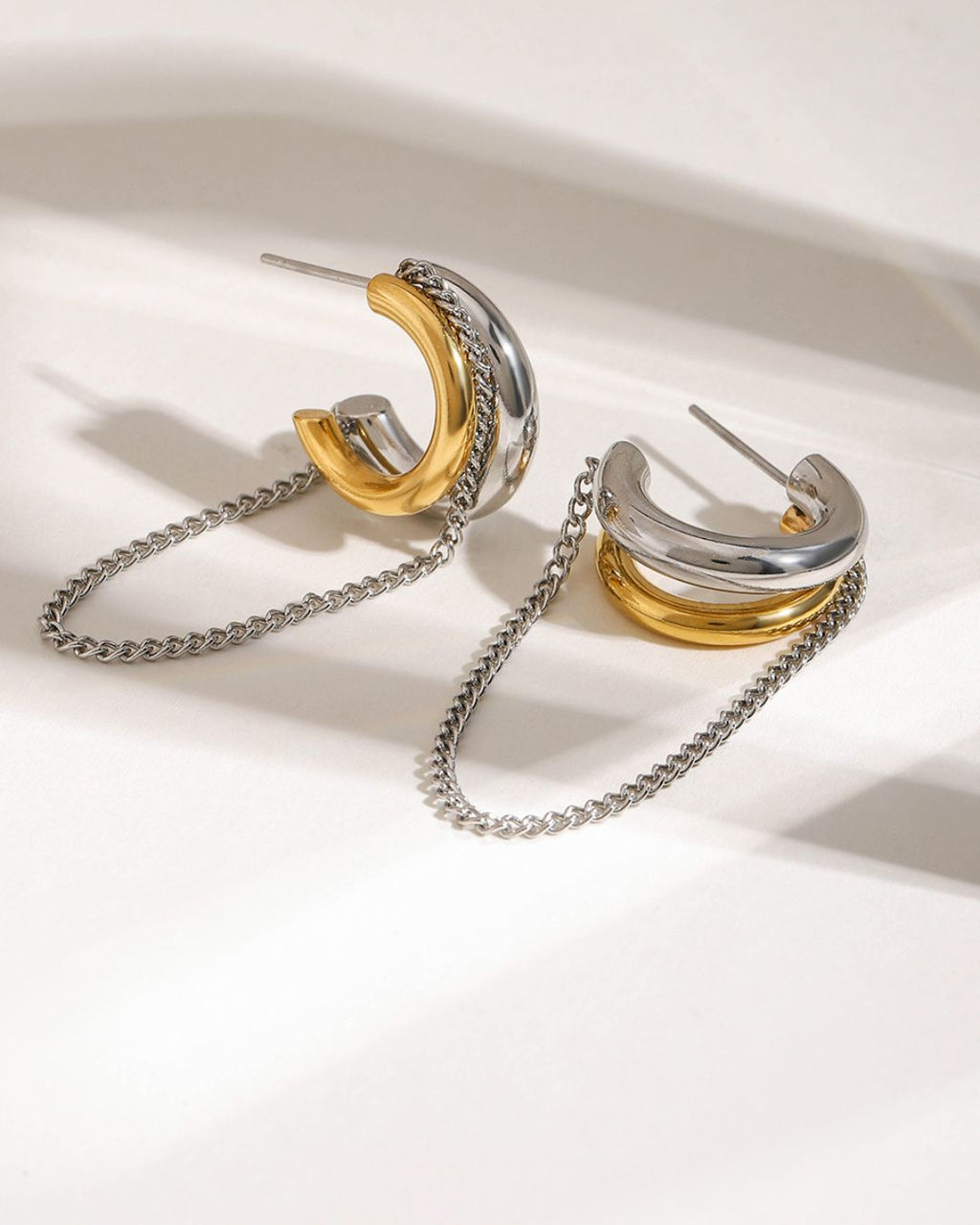 gold plated anti tarnish earrings Pair of gold and silver hoop earrings with chains on a white background