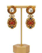 Decorative earrings on a gold stand with a white background