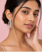 Model wearing Pearl Muse Hoops with classic statement pearl styling