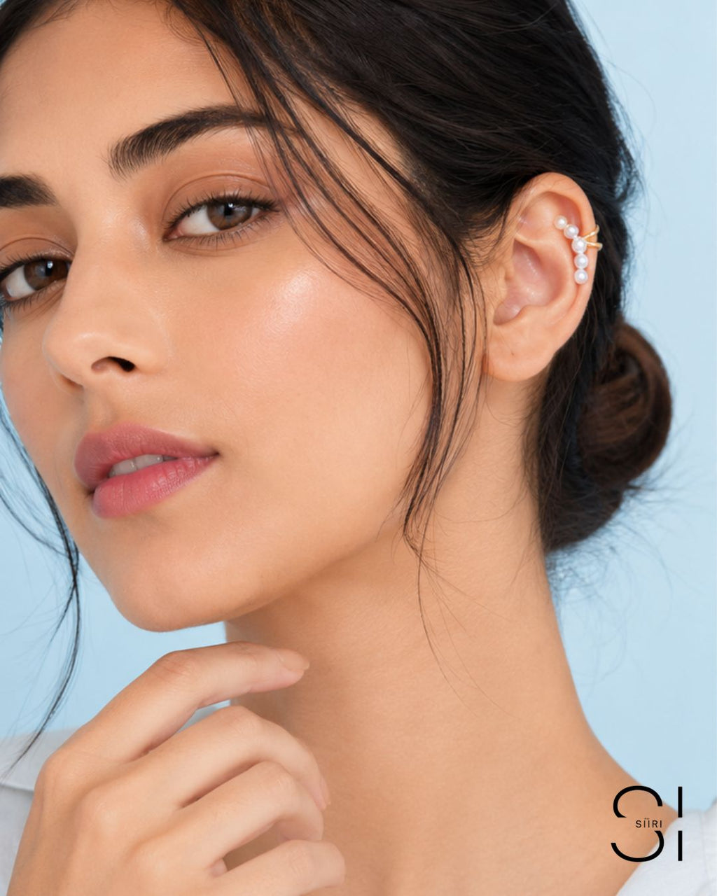 Model wearing a pearl ear cuff with gold plated accents and faux pearl embellishments