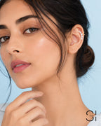 Model wearing a pearl ear cuff with gold plated accents and faux pearl embellishments