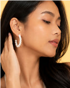 Close-up of a woman wearing pearl hoop earrings 