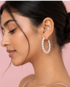 Woman wearing pearl hoop earrings for resort wear styling