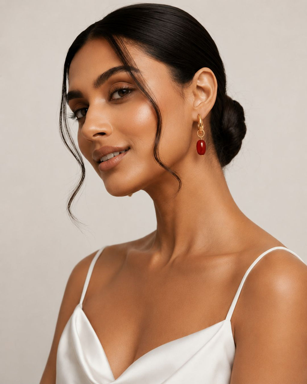 Woman wearing a white top and red earrings Close-up of Red Dual Style Earrings featuring convertible hoop and drop functionality with gold plated finish