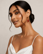 Woman wearing a white top and red earrings Close-up of Red Dual Style Earrings featuring convertible hoop and drop functionality with gold plated finish