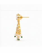 Gold earring with pearl and green gemstone drops on a white background